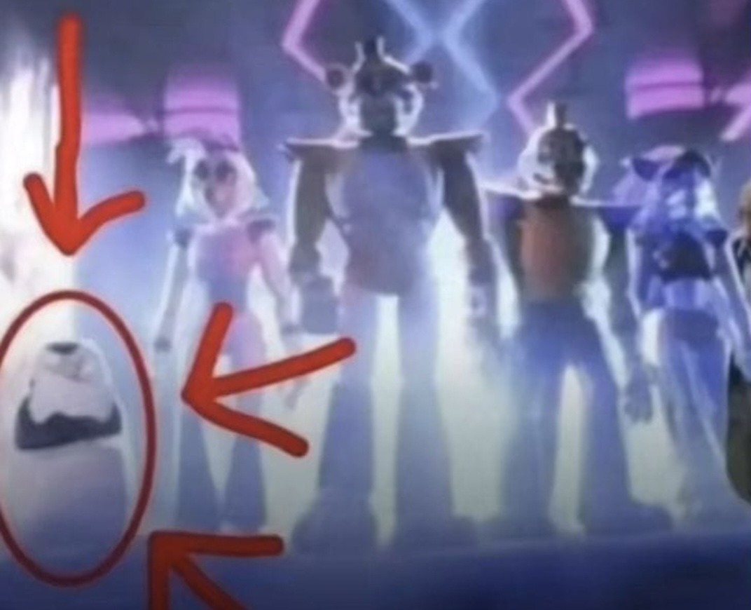 Pequeña figura blanca circundada en rojo frente a un grupo de figuras armadas en un escenario.