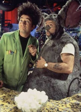 Dos hombres con disfraces frente a una mesa.