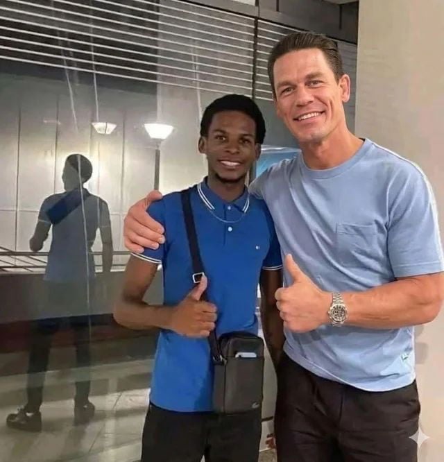 Two men posing for a photo, one is John Cena.