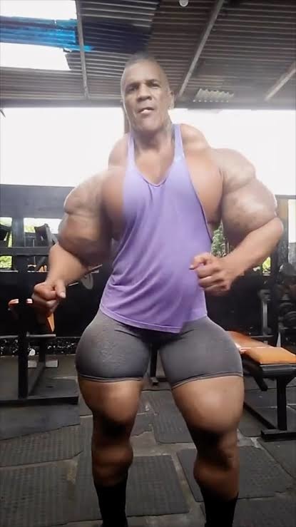 El hombre está en un gimnasio, mostrando sus músculos.