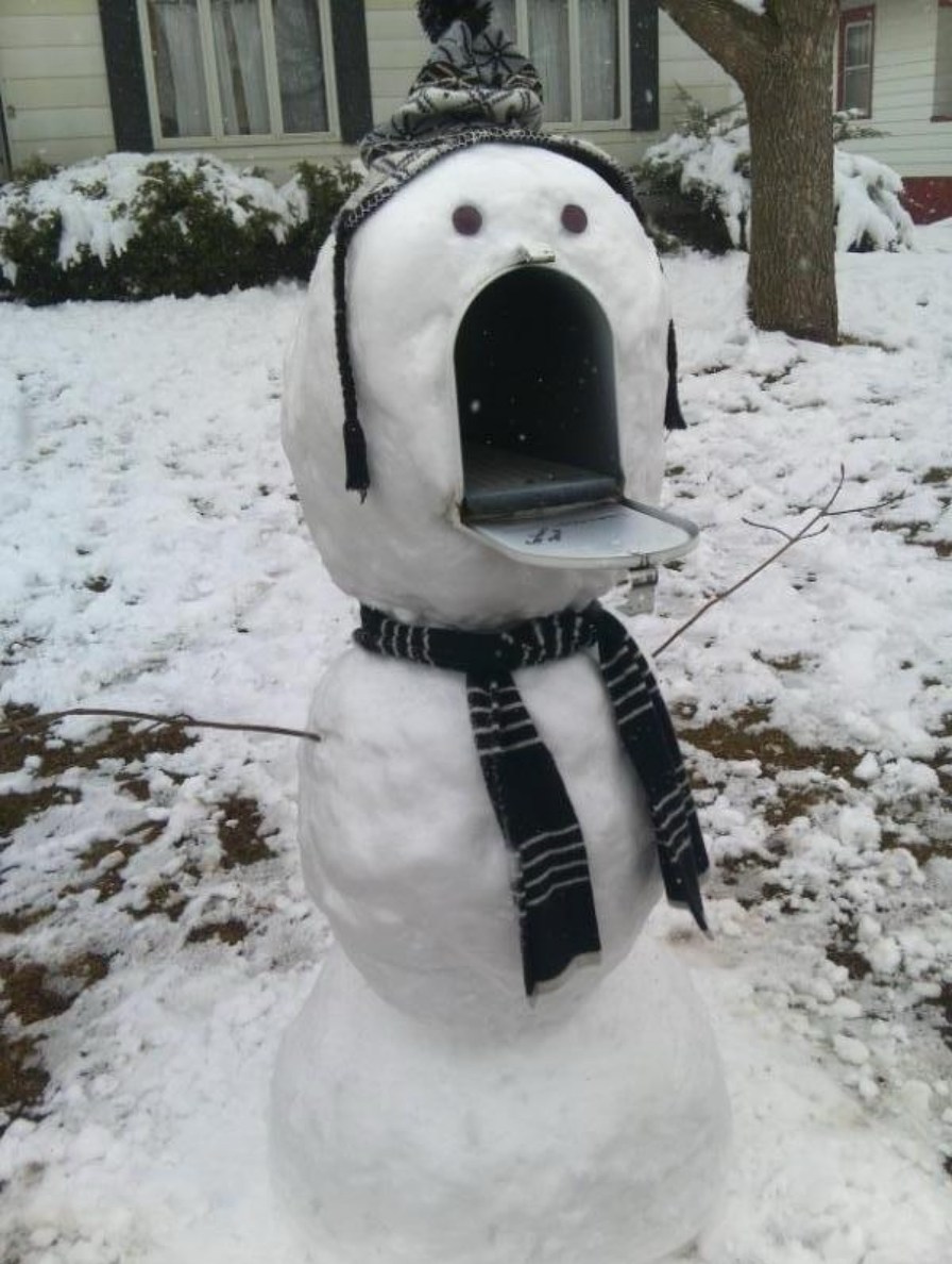 A snowman with a mailbox for a head, wearing a hat and scarf.