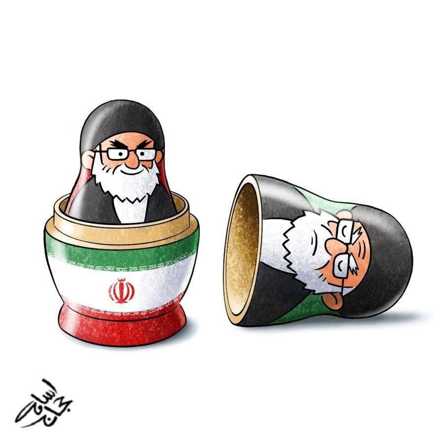 The image shows two Matryoshka dolls. One is standing upright and is open, revealing another doll inside. The outer doll is decorated with the flag of Iran. The inner doll is a caricature of a man with glasses and a beard. The second Matryoshka doll is lying on its side and is also open, revealing another doll inside. This inner doll is also a cari