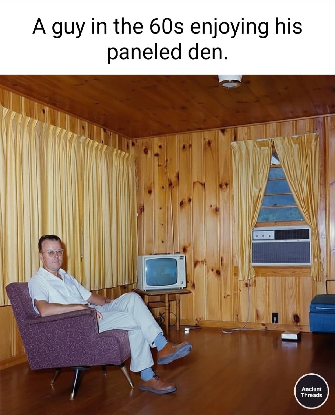 A guy in the 60s enjoying his paneled den.