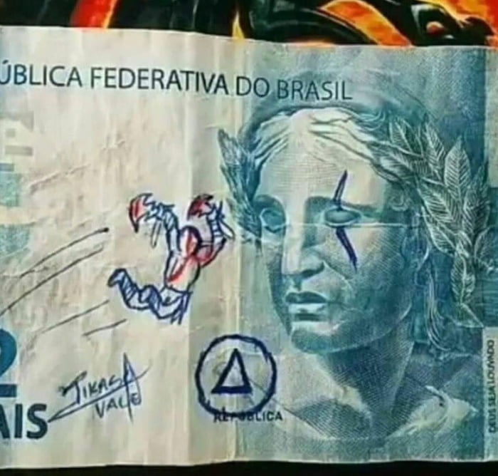REPÚBLICA FEDERATIVA DO BRASIL AIS JIKAS VALE REPÚBLICA DEUS SEJA LOUVADO. Uma nota de dinheiro brasileiro com um desenho do Kratos, personagem do jogo God of War, e um risco no olho da Efígie da República.