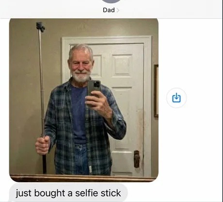 Dad sent a mirror selfie showing himself holding a selfie stick, with the text 'just bought a selfie stick'.