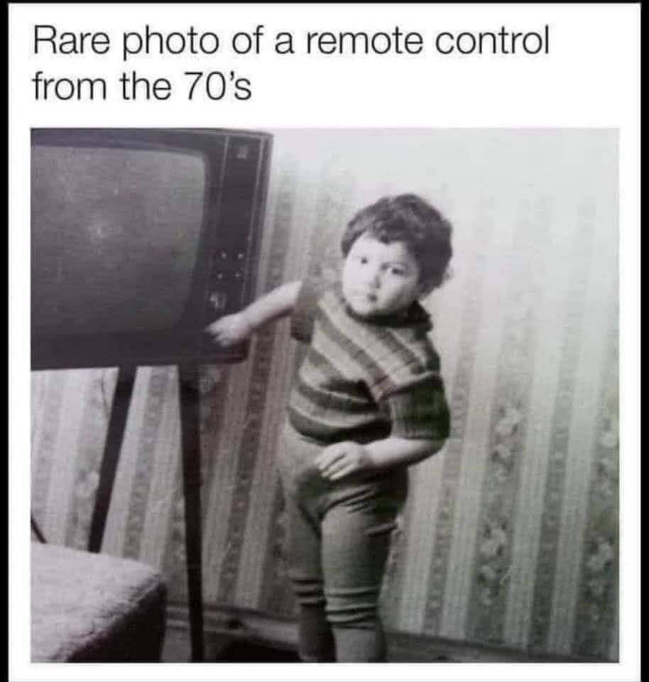 Rare photo of a remote control from the 70's. A black and white photo shows a small child pointing at a vintage television set, humorously implying the child is the 'remote control' for the TV.