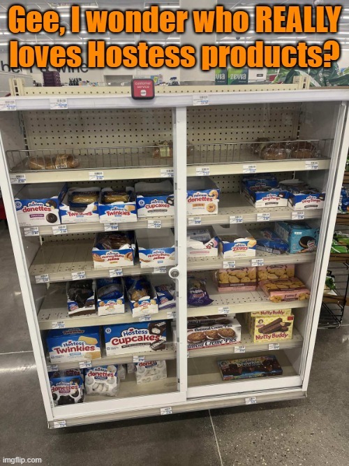 Gee, I wonder who REALLY loves Hostess products? The display case in the store is almost entirely empty, with only a few Hostess brand snacks remaining on the shelves, indicating high demand and popularity for these items.