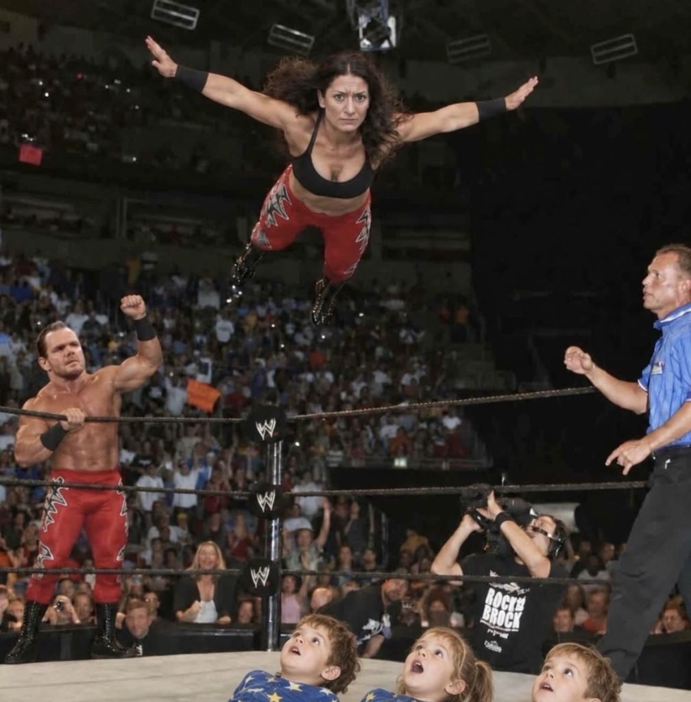 WWE logo on the ring posts. 'ROCKY BROCK' printed on a t-shirt.